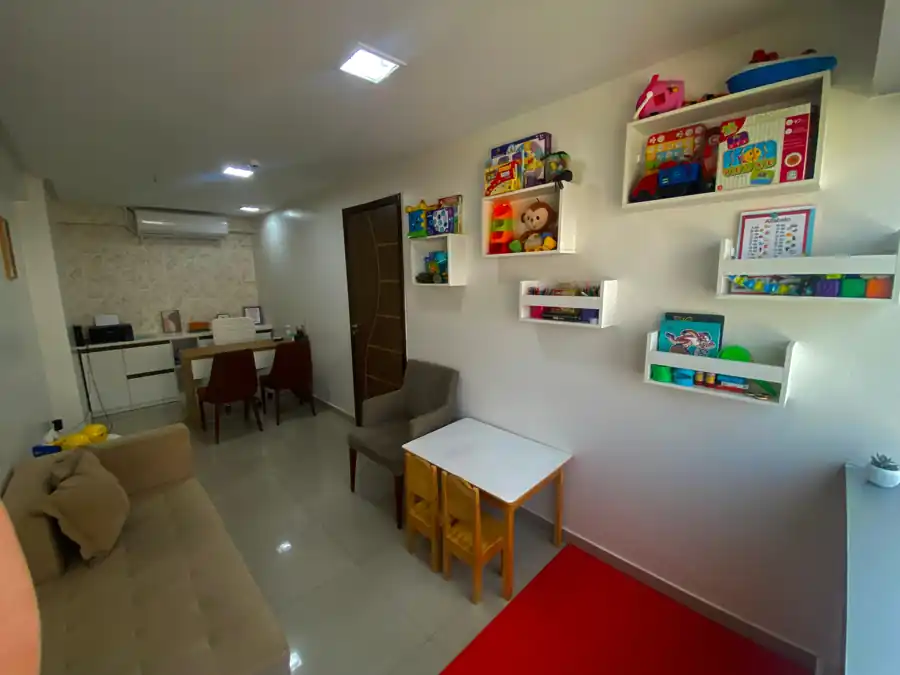 Sala de atendimento infantil da clínica, com mesa, brinquedos e área de acolhimento