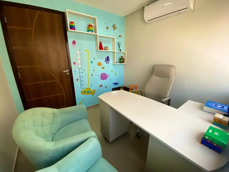Sala de atendimento com parede temática do fundo do mar e poltronas